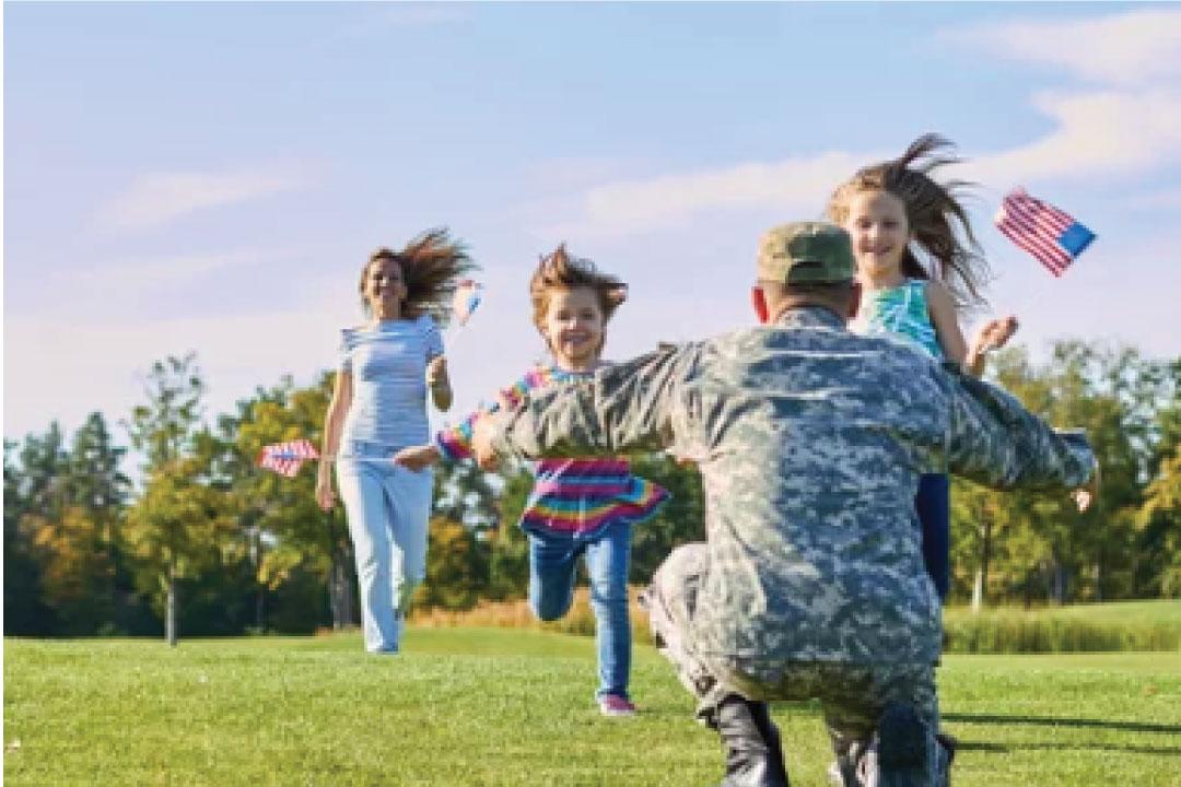 Two girls run toward their military dad.
